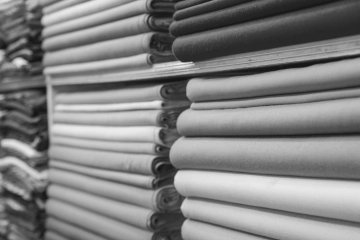 Rollos de tela de algodón peinado pesado y estándar para confección textil industrial.